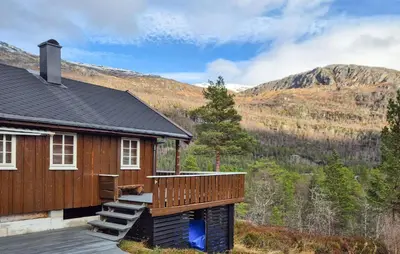 a house with a deck and mountains in the background at Amazing Home In Skare With Sauna in Skare