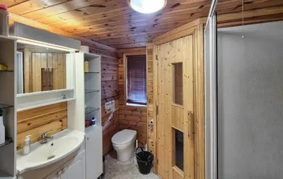 a bathroom with wooden walls and a toilet and a sink at Amazing Home In Skare With Sauna in Skare