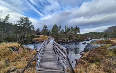 a wooden bridge over a river with a sky at Amazing Home In Skare With Sauna in Skare