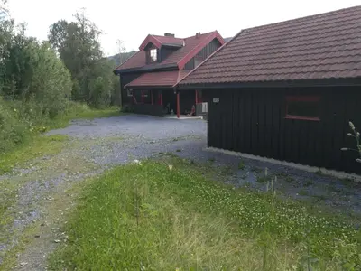 a building with a gravel driveway in front of it at Skap Opplevelser! in Svingvoll
