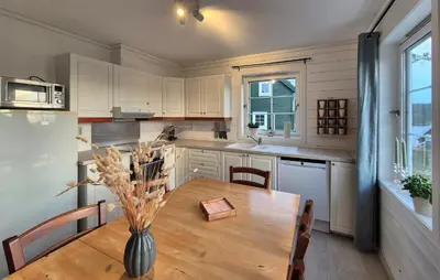 a kitchen with a wooden table with a vase on it at Beautiful Home In Bøvågen With Sauna in Bøvågen