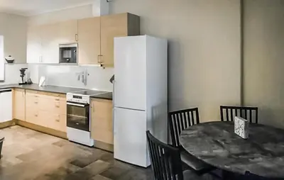 a kitchen with a table and a white refrigerator at 3 Bedroom Lovely Apartment In Eidfjord in Eidfjord