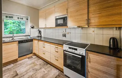 a kitchen with wooden cabinets and a stove top oven at 3 Bedroom Lovely Apartment In Eidfjord in Eidfjord