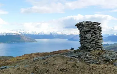 a stone tower on top of a mountain with a lake at 3 Bedroom Awesome Home In Strandebarm in Strandebarm