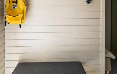 a wall with a yellow backpack and a bench at 3 Bedroom Awesome Home In Strandebarm in Strandebarm