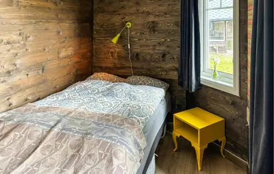 a small bedroom with a bed and a yellow table at Stunning Home In Røros With Sauna in Røros