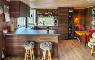 a kitchen with a counter and stools in a room at Stunning Home In Røros With Sauna in Røros