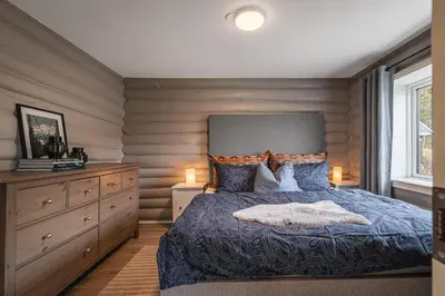 a bedroom with a bed and a wooden wall at Spacious Hemsedal home with ski slope view in Hemsedal