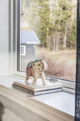 a toy elephant sitting on top of books on a window at Spacious Hemsedal home with ski slope view in Hemsedal