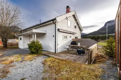 a house with a wooden deck next to a building at Spacious Hemsedal home with ski slope view in Hemsedal