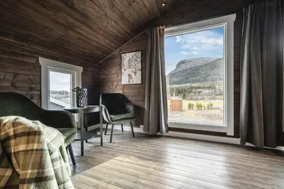 a bedroom with a large window and a table and chairs at Unique 'Stabbur' in Hemsedal, view to skislopes in Hemsedal