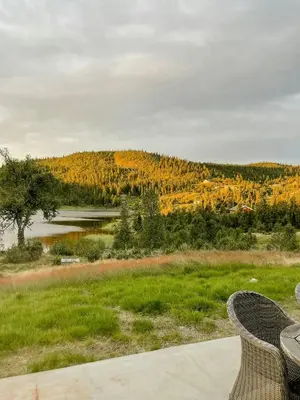 a view of a lake from a table and chairs at Family-Friendly Seter Cabin Near Makalaus Peak in Reinli