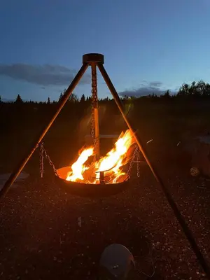 a fire pit with flames in the middle at Family-Friendly Seter Cabin Near Makalaus Peak in Reinli
