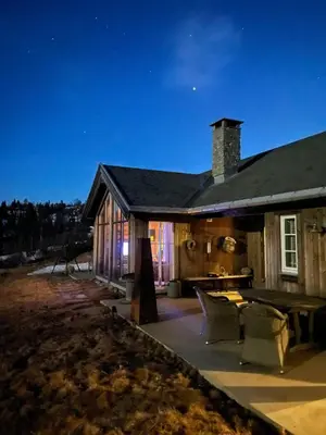 a large house with a patio at night at Family-Friendly Seter Cabin Near Makalaus Peak in Reinli