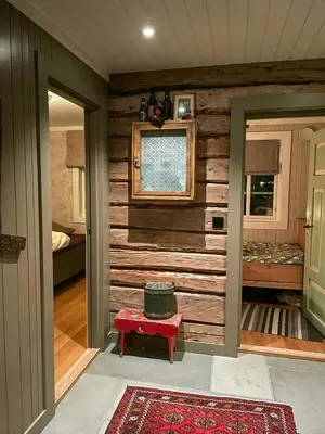 a room with a wooden wall with a pot on a stool at Family-Friendly Seter Cabin Near Makalaus Peak in Reinli