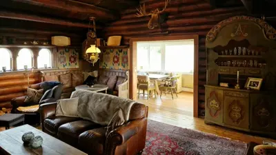 a living room with a couch and a table at Historic Cabin From 1906 In Sjusjøen in Sjusjøen