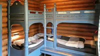 two bunk beds in a room with wooden walls at Historic Cabin From 1906 In Sjusjøen in Sjusjøen