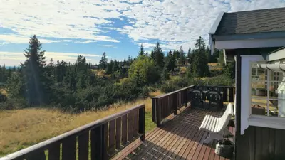a deck with a bench on a house at Historic Cabin From 1906 In Sjusjøen in Sjusjøen