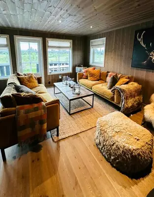 a living room with two couches and a table at Sunny Cabin With Panoramic Views At Golsfjellet in Tisleidalen