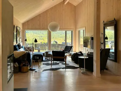 a living room with a couch and a table at Charming Mountain Cabin In Spectacular Nature in Brunstad
