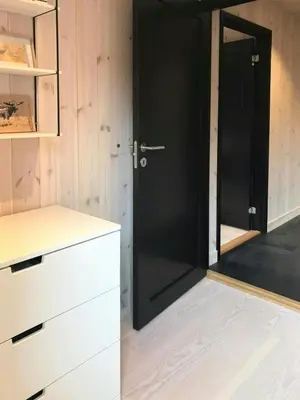 a black door in a kitchen with white cabinets at Charming Mountain Cabin In Spectacular Nature in Brunstad