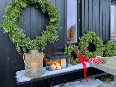a christmas porch with candles and a wreath at Charming Mountain Cabin In Spectacular Nature in Brunstad