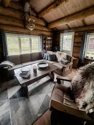 a living room with a couch and a table at Modern Hand-Crafted Log Cabin in Dovreskogen