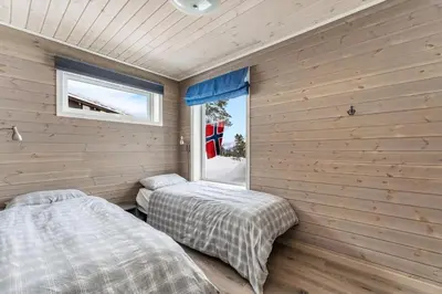two beds in a room with wooden walls at Modern Cabin Near Maldalsvatnet And Reinsnuten in Sauda