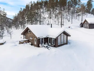 a cabin covered in snow with trees in the background at Modern Cabin Near Maldalsvatnet And Reinsnuten in Sauda