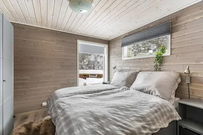 a bedroom with a bed in a room with wooden walls at Modern Cabin Near Maldalsvatnet And Reinsnuten in Sauda