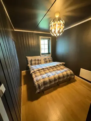a bedroom with a bed and a chandelier at Norefri - Norefjell in Noresund