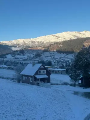 a house in a field with snow on the ground at Panoramic mountain views, space for the whole family in Vossevangen
