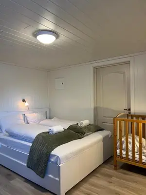 a bedroom with a large bed with white sheets at Panoramic mountain views, space for the whole family in Vossevangen
