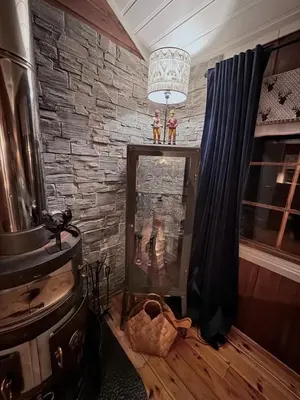 a living room with a fireplace and a stone wall at Utibakken - cabin ski inn-out Norefjell in Surteberg