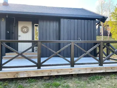 a black house with a porch with a fence at Utibakken - cabin ski inn-out Norefjell in Surteberg