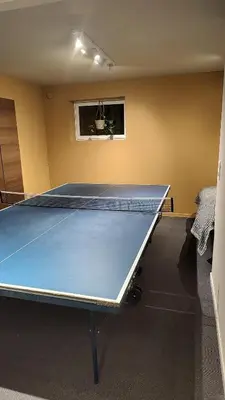 a ping pong table in a room at Splitter ny leilighet i sokkel på enebolig in Vikhammer