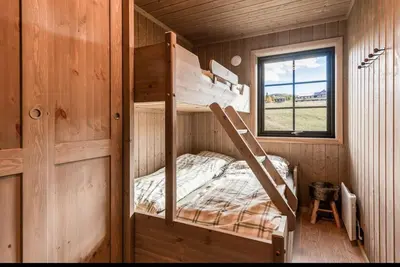 a bunk bed in a wooden cabin with a window at New Cabin With Views Of Tisleiefjorden in Gol