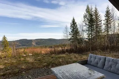 a couch sitting on a deck with a view of a field at Jantelaaven in Trysil