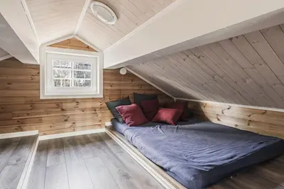 a bed in a room with wooden walls and a window at Jantelaaven in Trysil