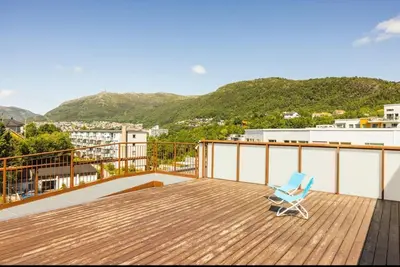 a blue chair sitting on top of a wooden deck at Great apartment in Bergen! in Lii