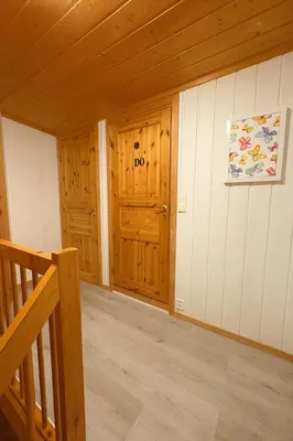 a room with wooden walls and a staircase in a cabin at Sentralt og elegant opphold nær alt in Lillehammer