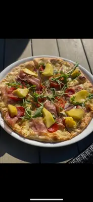 a pizza sitting on a plate on a table at Nygård Panorama in Stryn