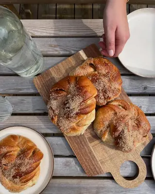 three pastries on a wooden cutting board on a table at Nygård Panorama in Stryn