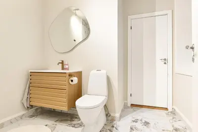 a bathroom with a white toilet and a mirror at Modern Apartment in Bergen