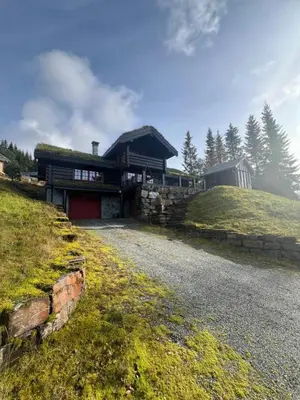 a building with a grass roof on top of a hill at Cabin in Kvamskogen in Kvam