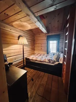 a bedroom with a bed in a log cabin at Cabin in Kvamskogen in Kvam