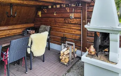 a patio with a fireplace and a table and chairs at Amazing Apartment In Braskereidfoss With Wifi in Braskereidfoss