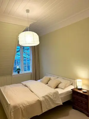 a bedroom with a large bed and a window at Historic villa with large garden in Stord
