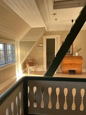 a room with a balcony with a railing at Historic villa with large garden in Stord