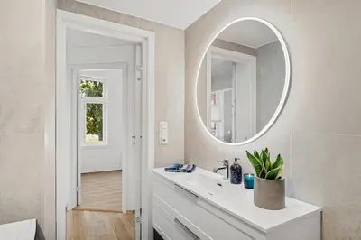 a bathroom with a white sink and a mirror at Central 3-room apartment in Trondheim